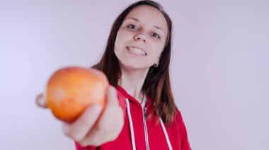 El Beyaz arka plan üzerinde izole kırmızı meyve tutan, yakın çekim. Kız yüz taze elma tutar. Bahçe ve sonbahar kavramı. Kadınlar sunar homegrown hasat