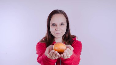 El Beyaz arka plan üzerinde izole kırmızı meyve tutan, yakın çekim. Kız yüz taze elma tutar. Bahçe ve sonbahar kavramı. Kadınlar sunar homegrown hasat