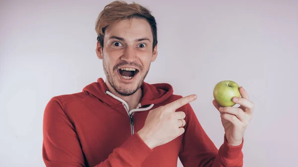 Ragazzo Con Viso Allegro Tiene Una Mela Verde Uno Sfondo — Foto Stock