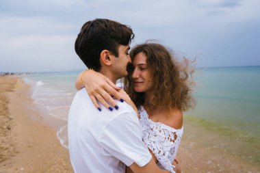 Mutlu çift sahilde ya da okyanusta geziniyor. Sahilde yürüyen aşk çifti.