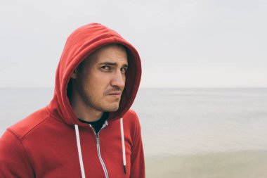 Kumlu bir plaj üzerinde duygusal bir adam. Deniz kıyısında atlet