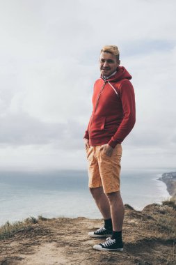 yakışıklı bir adam denize bakan bir dağ üzerinde sırtında