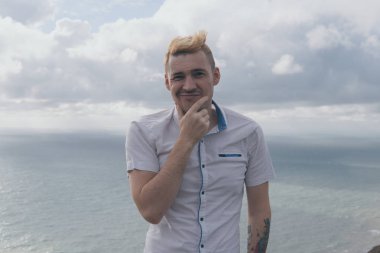 yakışıklı bir adam denize bakan bir dağ üzerinde sırtında