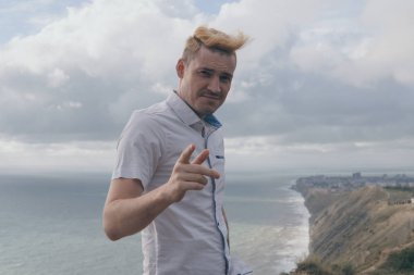 yakışıklı bir adam denize bakan bir dağ üzerinde sırtında