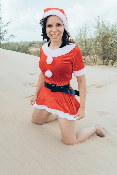 砂漠でサンタ クロースの格好の女の子 年末年始の旅行のコンセプトです メリー クリスマスと新年あけましておめでとうございます — ストック写真