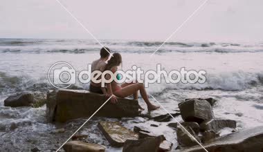 bir taş sahilde oturup aşık çift 