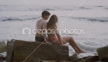 bir taş sahilde oturup aşık çift 