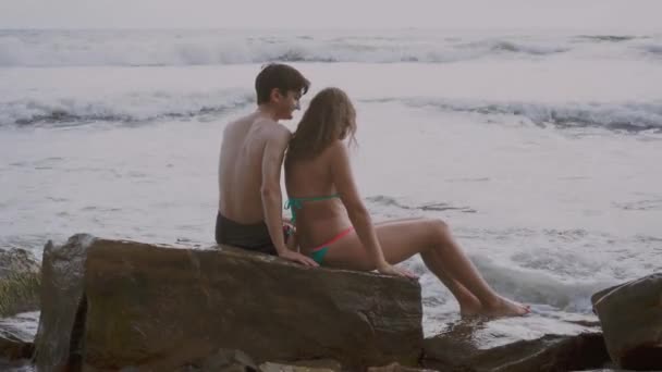 Ζευγάρι Στην Αγάπη Που Κάθεται Μια Πέτρα Στην Παραλία — Αρχείο Βίντεο