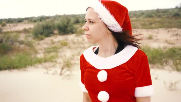 在沙漠中装扮成圣诞老人的女孩 新年假期旅行的概念 新年快乐 圣诞愉快 — 图库视频影像