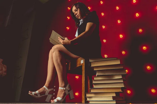 Girl Sitting Chair Reading Book Next Stack Books — Stock Photo, Image