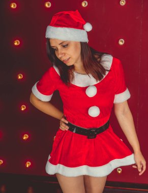 Parti, kutlama, Noel ve yeni yıl. Güzel kız kırmızı Santa Claus şapka giyiyor. Kırmızı zemin şehvetli Noel kız. Seksi Noel Baba yardımcı kız. Yeni yıl, Noel zamanı, tatil kutlaması.