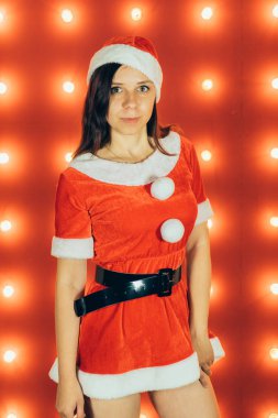 Parti, kutlama, Noel ve yeni yıl. Güzel kız kırmızı Santa Claus şapka giyiyor. Kırmızı zemin şehvetli Noel kız. Seksi Noel Baba yardımcı kız. Yeni yıl, Noel zamanı, tatil kutlaması.
