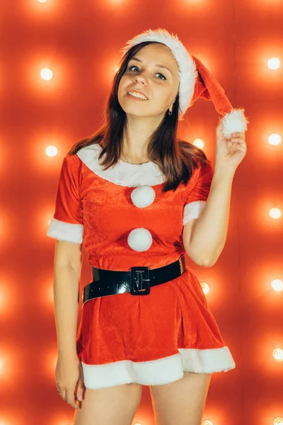 圣诞节和新年 漂亮的女孩穿着红色的圣诞老人帽子 性感的圣诞女孩在红色背景 性感的圣诞老人助手女孩 圣诞节 节日庆典 — 图库照片