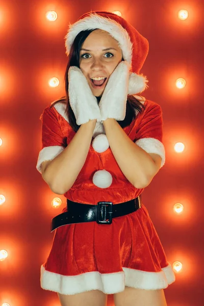 圣诞节和新年 漂亮的女孩穿着红色的圣诞老人帽子 性感的圣诞女孩在红色背景 性感的圣诞老人助手女孩 圣诞节 节日庆典 — 图库照片