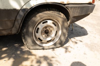 Terk edilmiş bir paslı araba üzerinde düz bir lastik