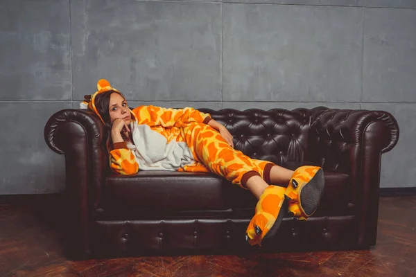 Pajamas Forma Uma Girafa Retrato Emocional Estudante Sofá Couro Fundo — Fotografia de Stock