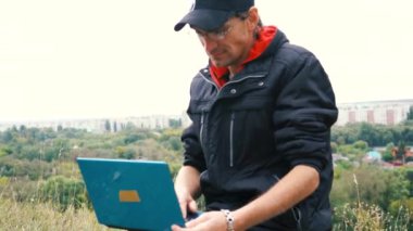 Bir dizüstü bilgisayar açık havada kullanma yakışıklı delikanlı. Öğrenci hoş bir atmosfer açık havada içinde laptop ile studyin üzerinde duruldu. Teknoloji, iletişim, eğitim ve uzak çalışma kavramı