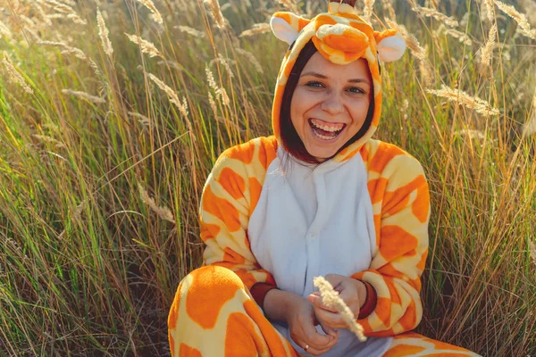Kız gülümsüyor. Komik zürafa kostüm, duygusal öğrenci komik pijama buğday tarlasında oturuyor. Çocuk partisi için kavram animator.