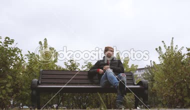 Yakışıklı delikanlı bir cep telefonu tutan bir akıllı telefon kullanan, sonbaharda sokakta telefonda konuşurken bir çağrı yapar