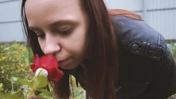 美しい女性の肖像画は 公園のバラの花を傍受します クローズ アップ顔とローズ 横から見た図 — ストック動画