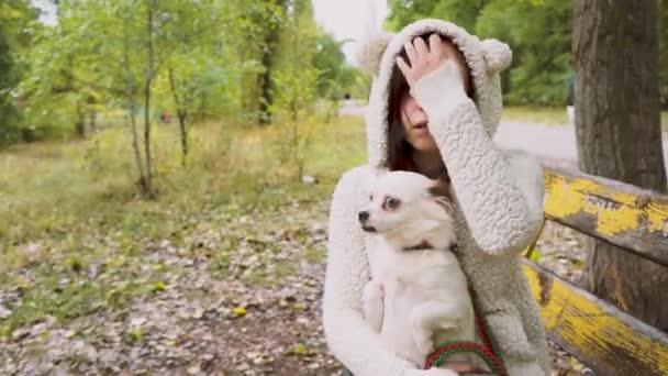 Κορίτσι Και Σκύλο Που Κάθεται Στον Πάγκο Φθινόπωρο — Αρχείο Βίντεο