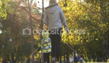 Anne ve kızı sonbahar park ayak üzerinde yürümek