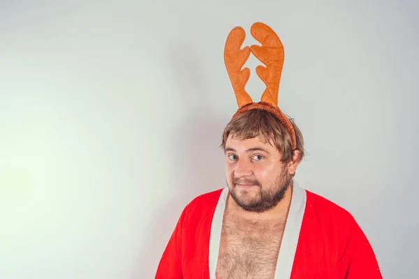 Christmas, holidays and people concept - a man\'s head with deer horns on it. Man scratches his head.