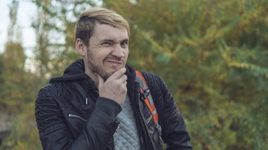 Sonbahar doğaya karşı poz yakışıklı bir adam. Sokakta bir deri ceketli sarışın