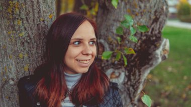 Bir ağacın yanında poz güzel genç kız