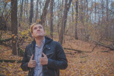 Sonbahar Park yürüyen genç adam. Adam açık havada sonbaharda. Öğrenci Park sonbaharda yürür