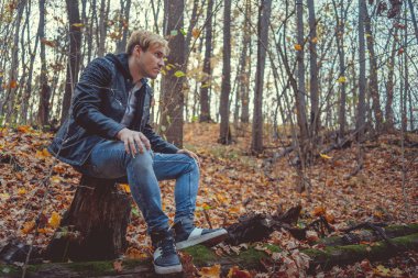 Sonbahar Park yürüyen genç adam. Adam açık havada sonbaharda. Öğrenci Park sonbaharda yürür