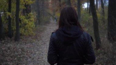 Genç kız sonbahar Park'ta yürüyordunuz. Kadınlarda sonbahar arka plan açık havada. Kız akşam sonbahar parkta yürüyüş