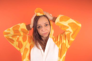 pijama bir zürafa şeklinde. duygusal portre turuncu bir arka plan bir kız. takım elbiseli çılgın ve komik bir kadın. çocuk partileri için animatör