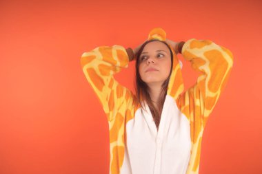 pijama bir zürafa şeklinde. duygusal portre turuncu bir arka plan bir kız. takım elbiseli çılgın ve komik bir kadın. çocuk partileri için animatör