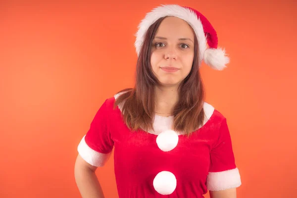 在橙色背景打扮成圣诞老人的年轻女孩的肖像 新年快乐 圣诞快乐 — 图库照片