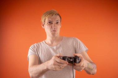 bir gamepad onun elinde tutan genç bir adam. duygusal portre. adam ile bilgisayar oyunu oynamak. Konsept: duygusal oyun