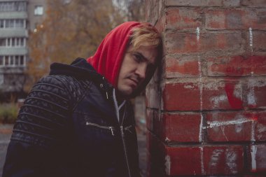 Genç bir adam sokakta yürürken bir deri ceketli. duygusal portre. bir adamın temiz hava girer. sokak tarzı kıyafetler bir şehirde yürümek için. Giyim Katalog için duvar kağıtları.