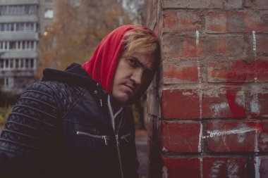 Genç bir adam sokakta yürürken bir deri ceketli. duygusal portre. bir adamın temiz hava girer. sokak tarzı kıyafetler bir şehirde yürümek için. Giyim Katalog için duvar kağıtları.