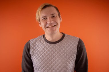 Yakışıklı genç gri süveterli turuncu arka plan üzerinde poz