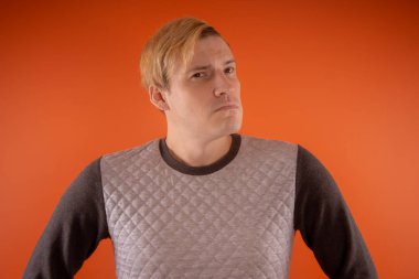 Yakışıklı genç gri süveterli turuncu arka plan üzerinde poz