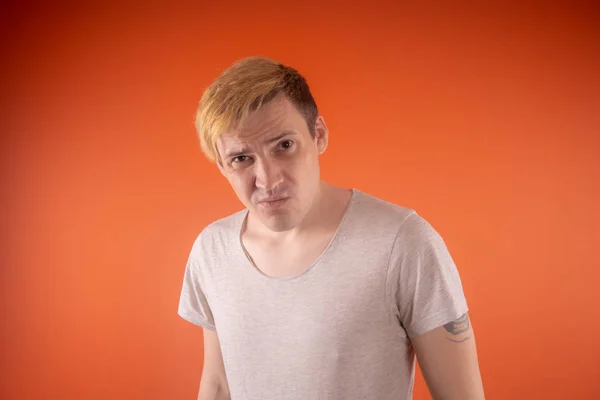 Όμορφη Νεαρός Άνδρας Στο Ελαφρύ Shirt Θέτοντας Πορτοκαλί Φόντο — Φωτογραφία Αρχείου
