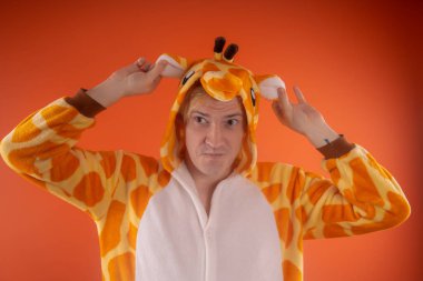 pijama bir zürafa şeklinde. turuncu bir arka plan üzerinde bir adam duygusal portresi. elbiseli çılgın ve komik adam. Çocuk partilerine için animatör