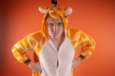 pijama bir zürafa şeklinde. turuncu bir arka plan üzerinde bir adam duygusal portresi. elbiseli çılgın ve komik adam. Çocuk partilerine için animatör