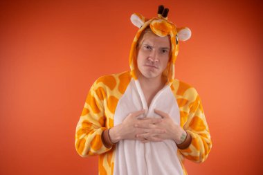 pijama bir zürafa şeklinde. turuncu bir arka plan üzerinde bir adam duygusal portresi. elbiseli çılgın ve komik adam. Çocuk partilerine için animatör