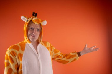 pijama bir zürafa şeklinde. turuncu bir arka plan üzerinde bir adam duygusal portresi. elbiseli çılgın ve komik adam. Çocuk partilerine için animatör