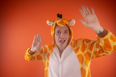 pijama bir zürafa şeklinde. turuncu bir arka plan üzerinde bir adam duygusal portresi. elbiseli çılgın ve komik adam. Çocuk partilerine için animatör