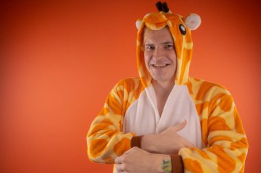 pijama bir zürafa şeklinde. turuncu bir arka plan üzerinde bir adam duygusal portresi. elbiseli çılgın ve komik adam. Çocuk partilerine için animatör