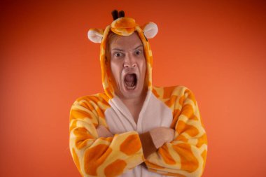 pijama bir zürafa şeklinde. turuncu bir arka plan üzerinde bir adam duygusal portresi. elbiseli çılgın ve komik adam. Çocuk partilerine için animatör