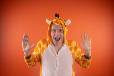 pijama bir zürafa şeklinde. turuncu bir arka plan üzerinde bir adam duygusal portresi. elbiseli çılgın ve komik adam. Çocuk partilerine için animatör