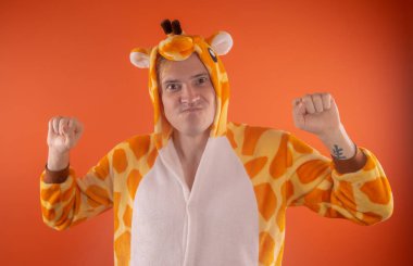 pijama bir zürafa şeklinde. turuncu bir arka plan üzerinde bir adam duygusal portresi. elbiseli çılgın ve komik adam. Çocuk partilerine için animatör